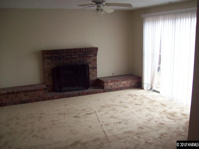 1835 Becky Court Reno, NV 89503 - Photo 2 of 4 an empty room with a fireplace and fan