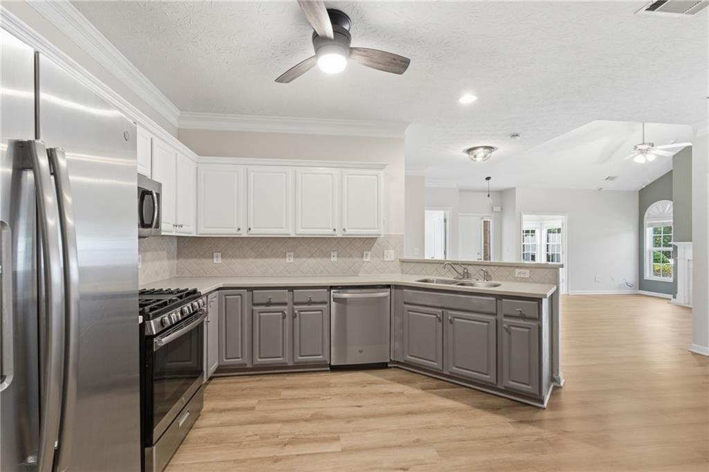4533 Caleb Crossing, Unit 18 Powder Springs, GA 30127 - Photo 5 of 24 a kitchen with stainless steel appliances granite countertop a sink stove and refrigerator