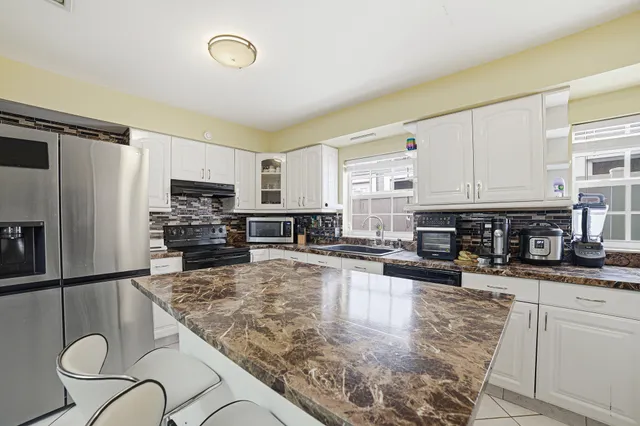 a kitchen with stainless steel appliances granite countertop a sink stove and refrigerator