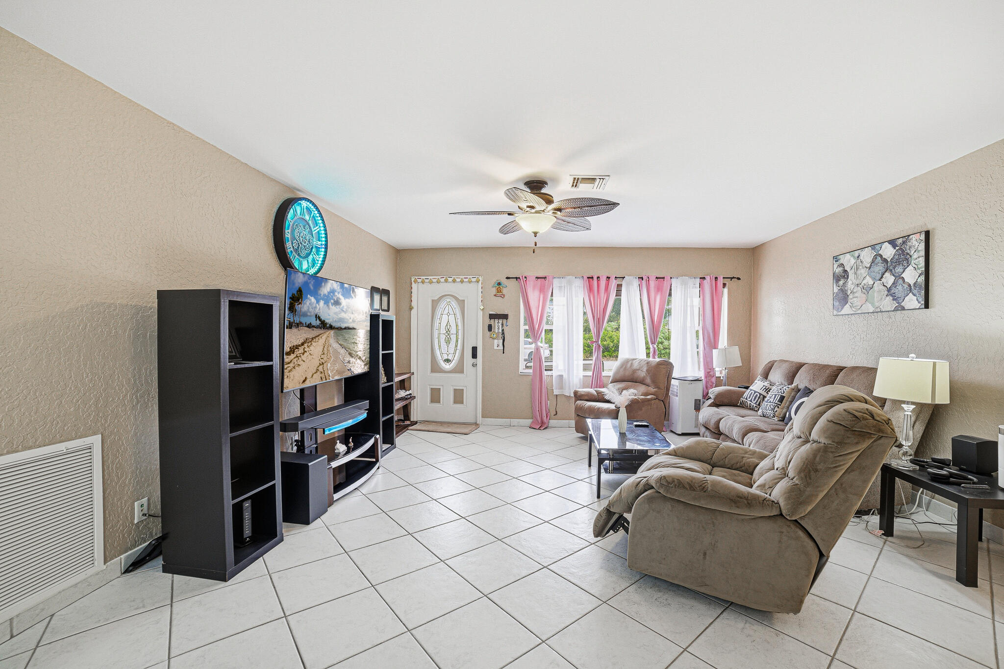 564 Northwest 55th Street Boca Raton, FL 33487 - Photo 5 of 26 a living room with furniture a flat screen tv and a window