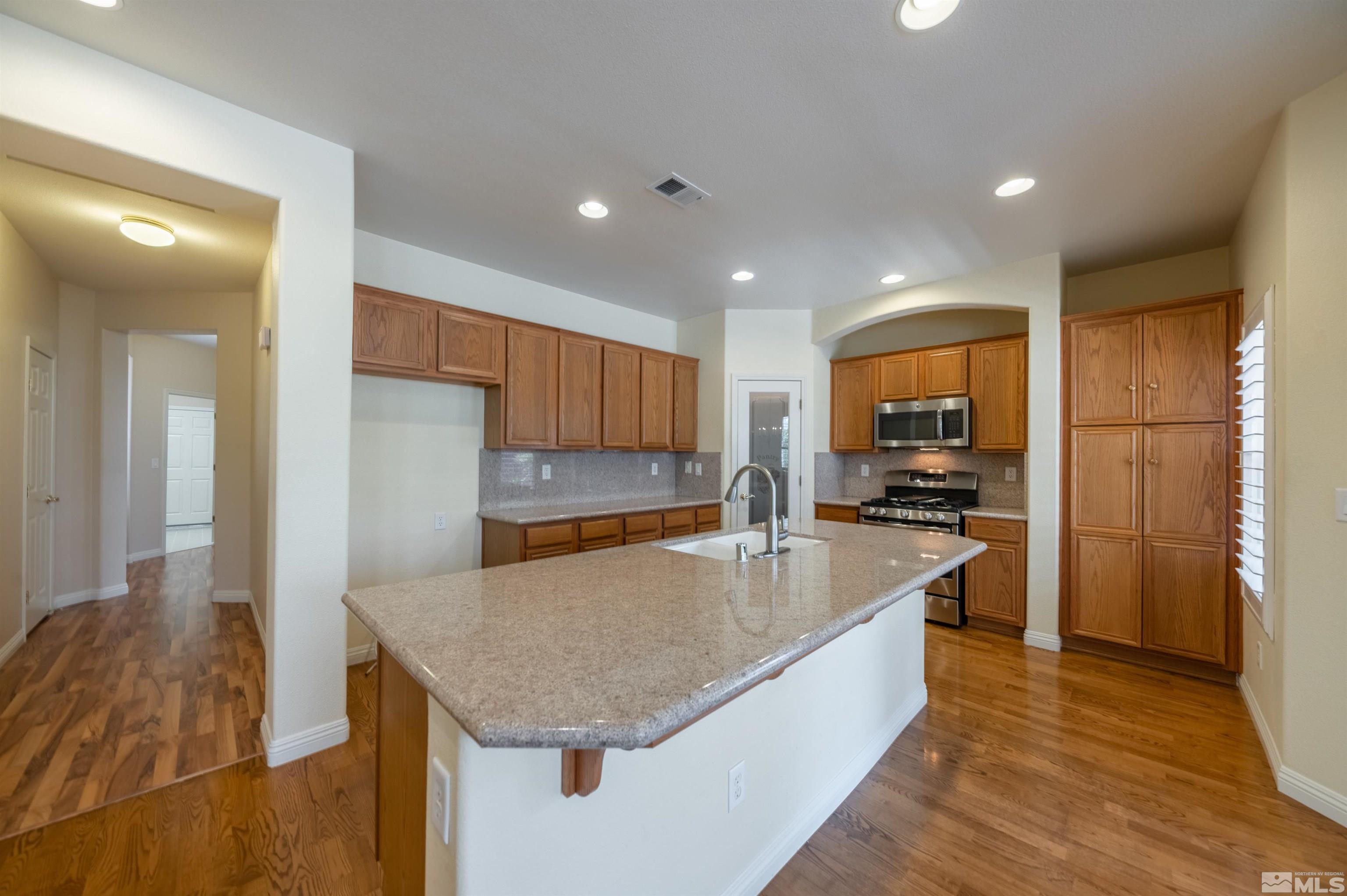 1416 Wild Wolf Way Reno, NV 89521 - Photo 16 of 39 a large kitchen with kitchen island a large counter top stainless steel appliances and cabinets
