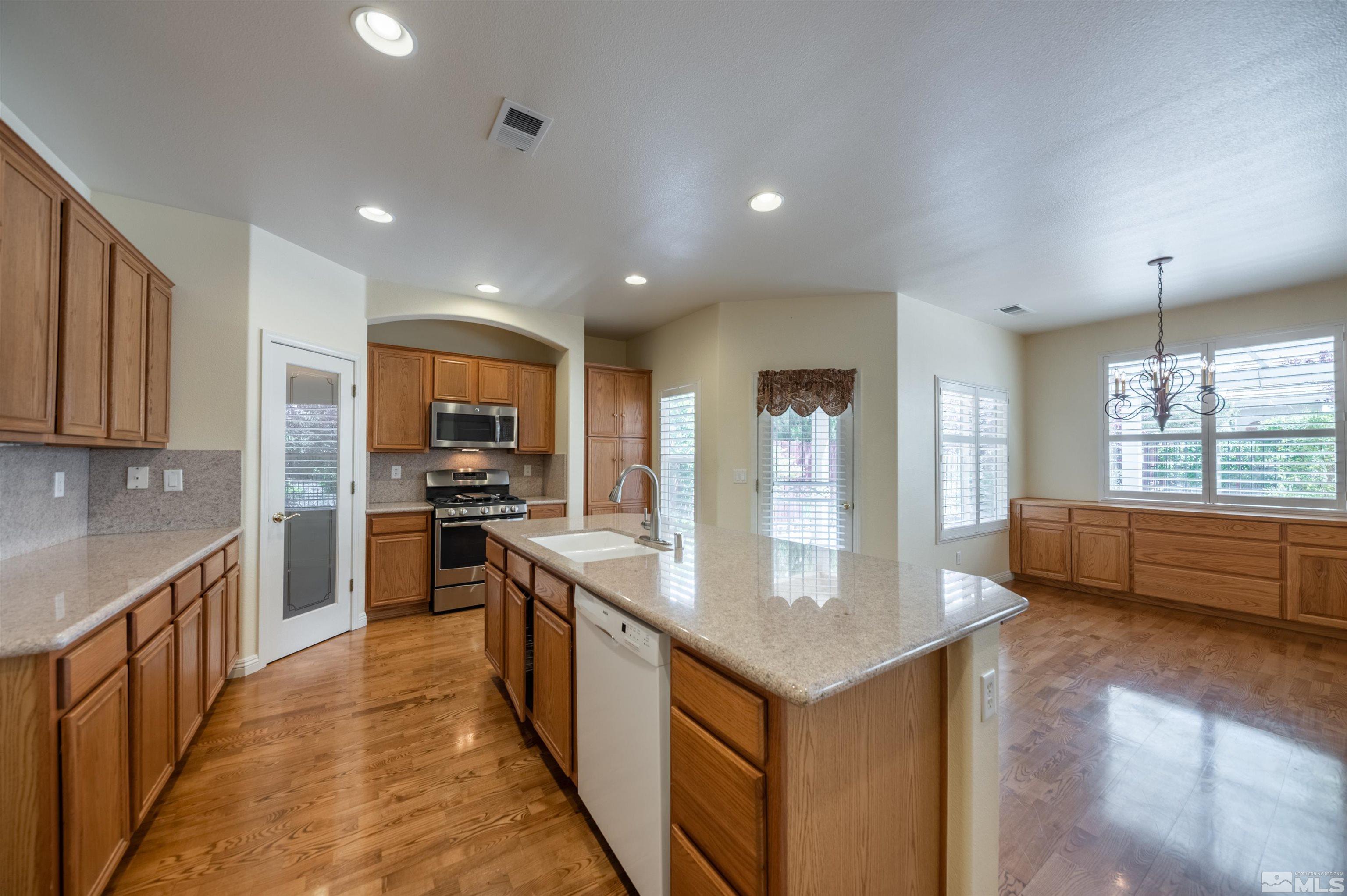 1416 Wild Wolf Way Reno, NV 89521 - Photo 17 of 39 a kitchen with stainless steel appliances granite countertop a refrigerator and a stove top oven
