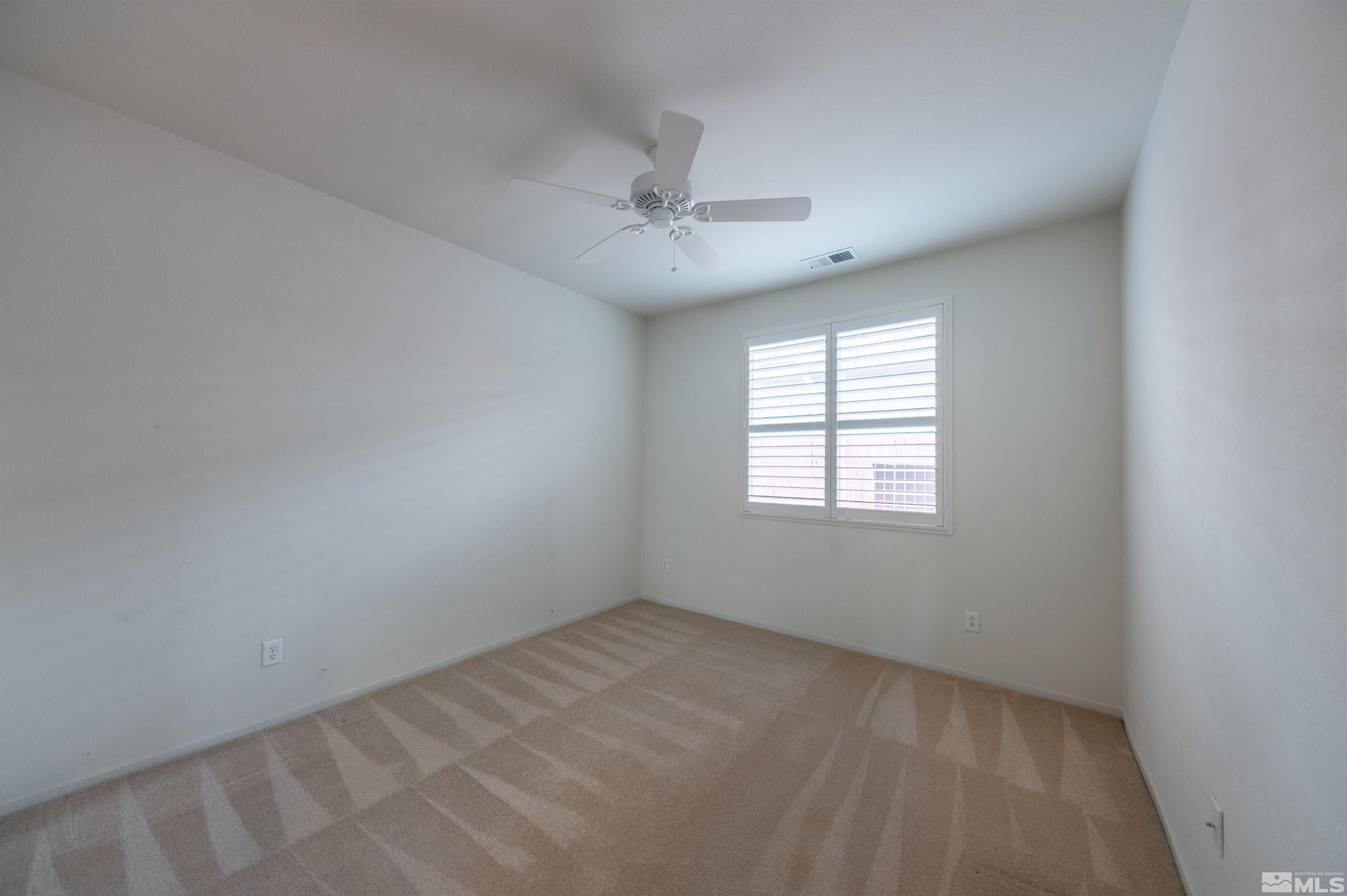 1416 Wild Wolf Way Reno, NV 89521 - Photo 31 of 39 an empty room with a window and a ceiling fan