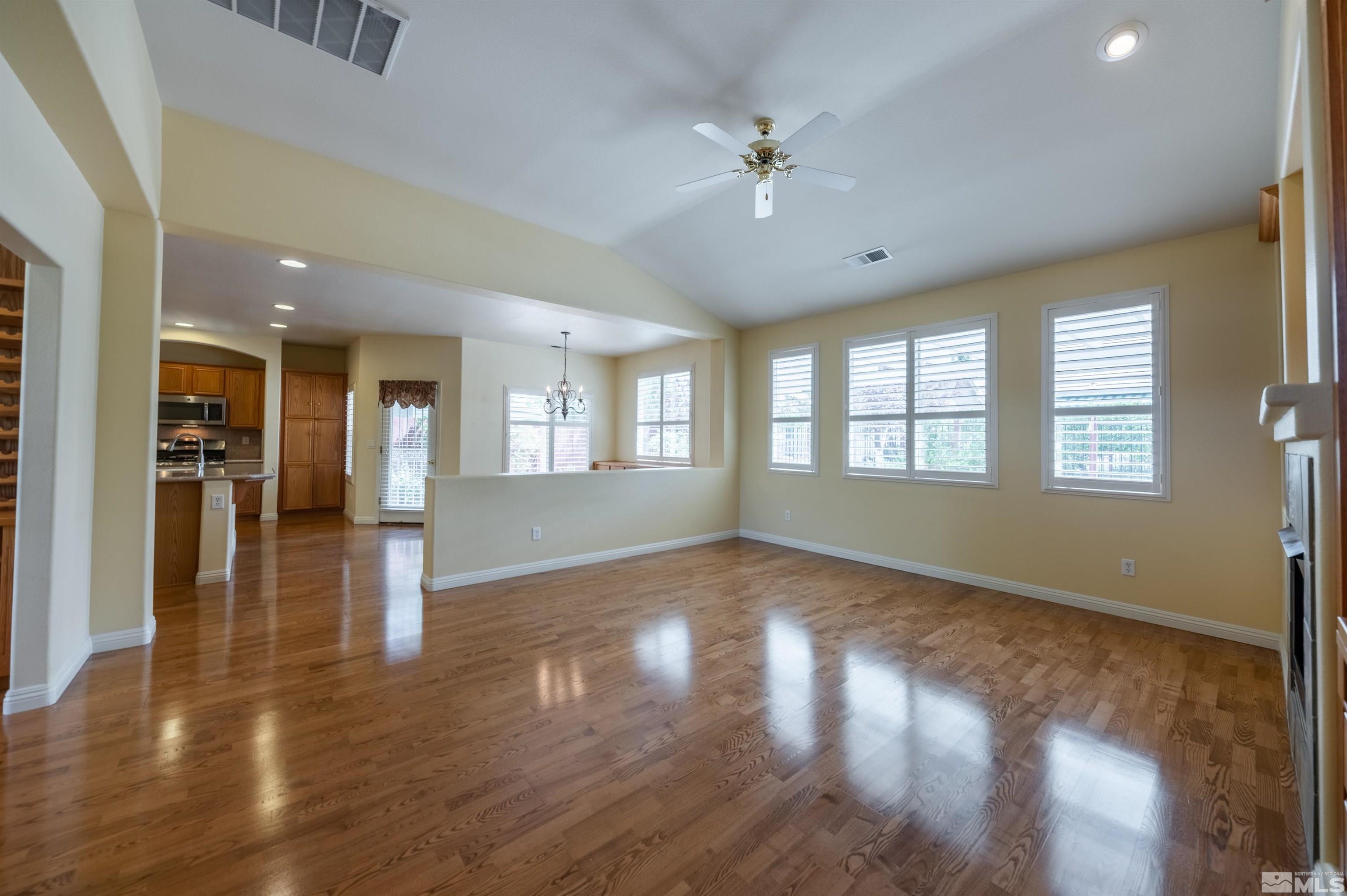 1416 Wild Wolf Way Reno, NV 89521 - Photo 8 of 39 a view of an empty room with wooden floor and a kitchen