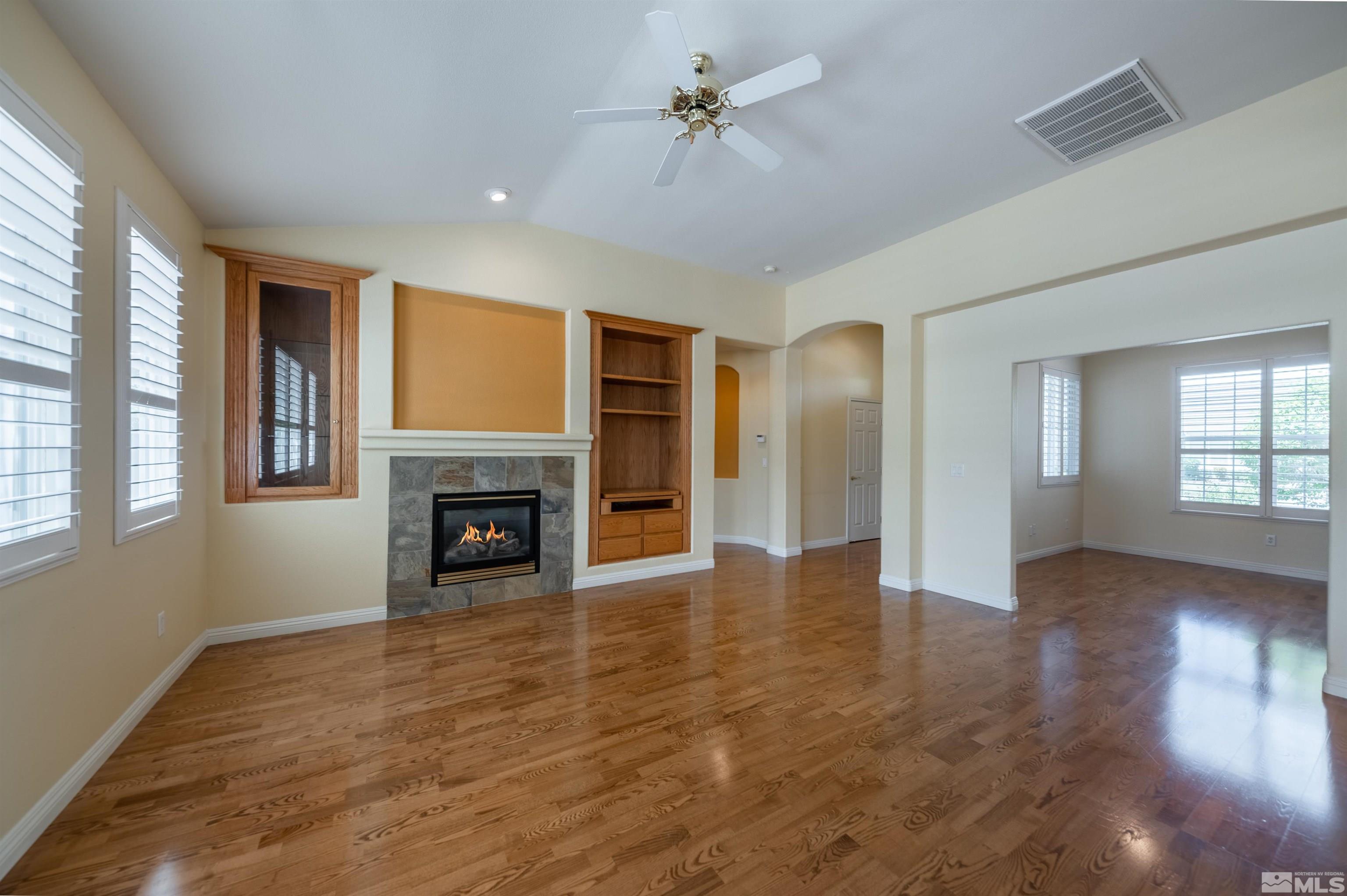 1416 Wild Wolf Way Reno, NV 89521 - Photo 10 of 39 a view of an empty room with wooden floor fireplace and a window