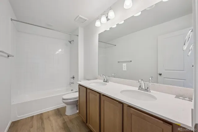 a bathroom with a sink a toilet a mirror and shower