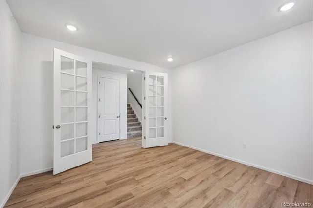 an empty room with wooden floor and windows