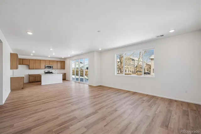 a view of kitchen and hall with wooden floor