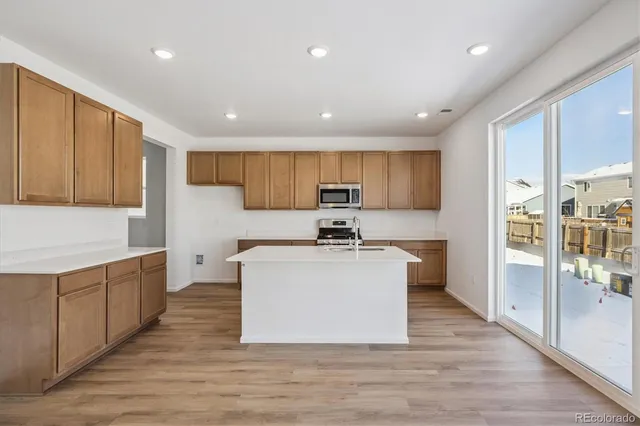 a large kitchen with stainless steel appliances sink a microwave and cabinets