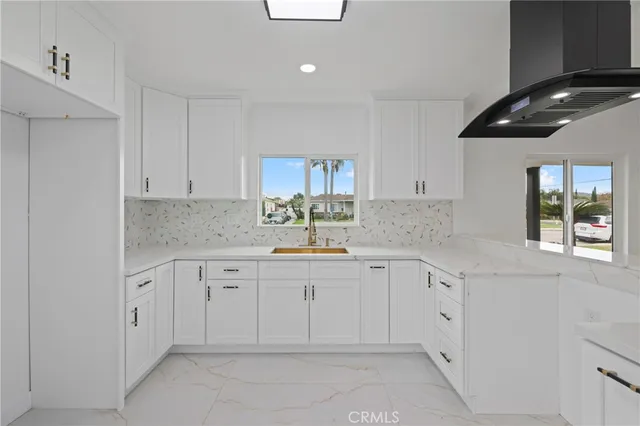 a kitchen with white cabinets appliances a sink