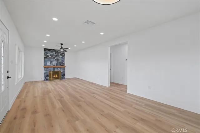 a view of empty room with wooden floor and window