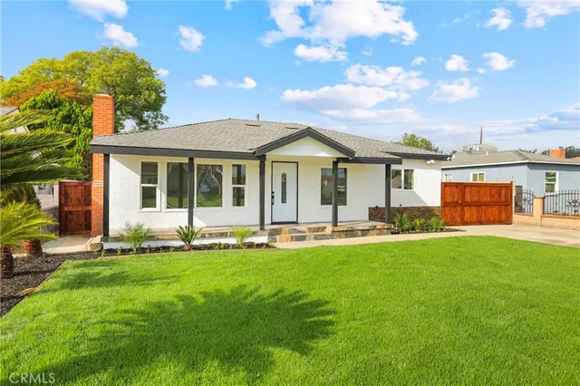 a front view of a house with a garden and patio
