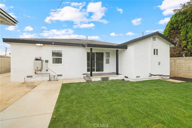 a view of a house with a backyard and a tree