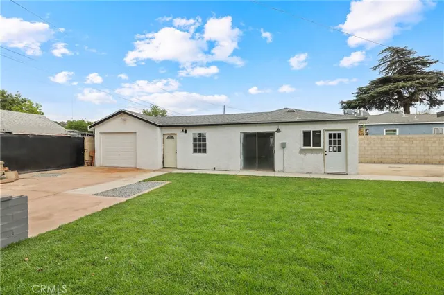 a view of a yard in front of a house with large trees