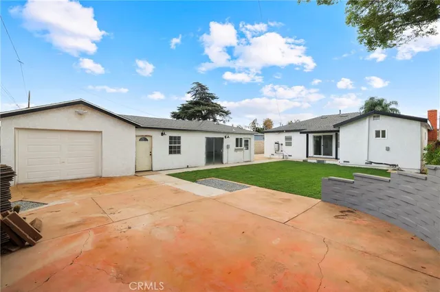 a view of a house with a yard and large tree