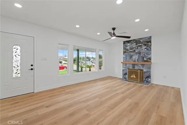 an empty room with windows and fireplace