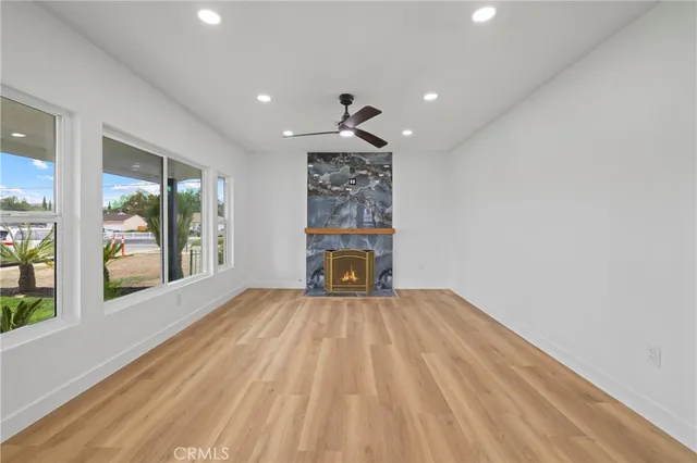 a view of a room with wooden floor fireplace and windows