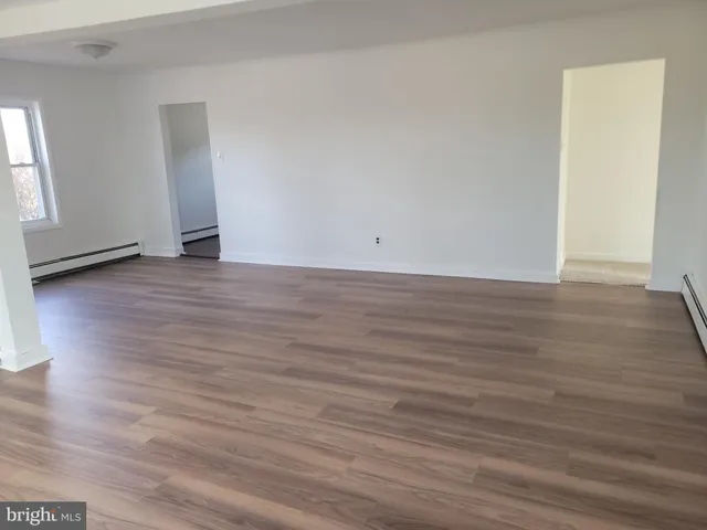 a view of an empty room and wooden floor