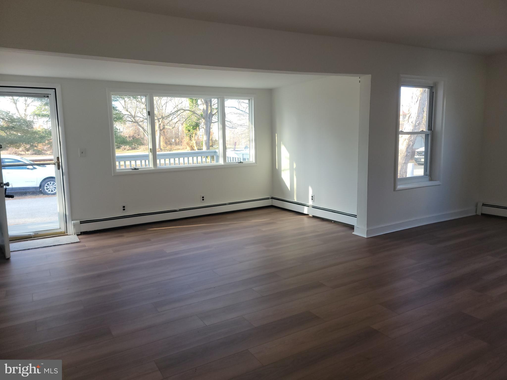 239 J Street Carneys Point, NJ 08069 - Photo 8 of 19 an empty room with wooden floor and windows