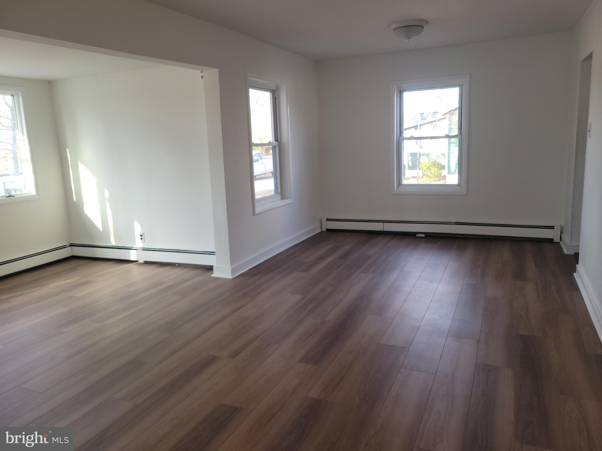 239 J Street Carneys Point, NJ 08069 - Photo 9 of 19 an empty room with wooden floor and windows