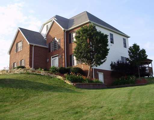 Exterior Front. Side Entrance to basement offers easy storage access.  Basement is large and is plumbed for an additional bath and fireplace flue is in-place.