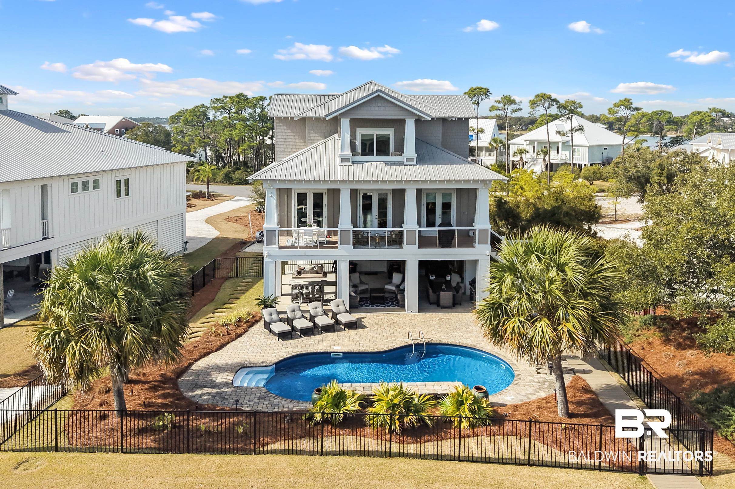 33186 Marlin Key Drive Orange Beach, AL 36561 - Photo 5 of 87 Rear view of house featuring a balcony, a fenced backyard, a patio area, a metal roof, and a residential view