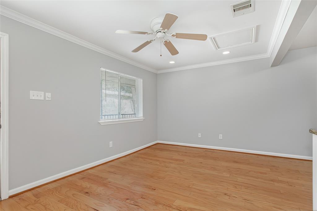 4931 Junius Street, Unit 8 Dallas, TX 75214 - Photo 4 of 31 an empty room with wooden floor ceiling fan and windows
