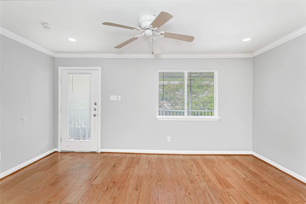 4931 Junius Street, Unit 8 Dallas, TX 75214 - Photo 9 of 31 an empty room with wooden floor ceiling fan and windows
