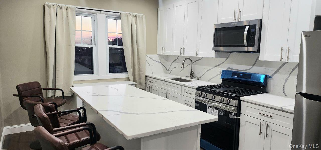 25 Allard Avenue New Rochelle, NY 10805 - Photo 4 of 8 a kitchen with a stove and a microwave