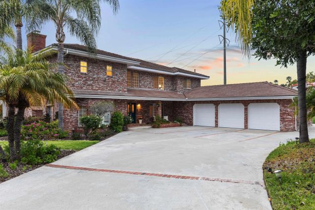 a view of a house with a yard and palm trees