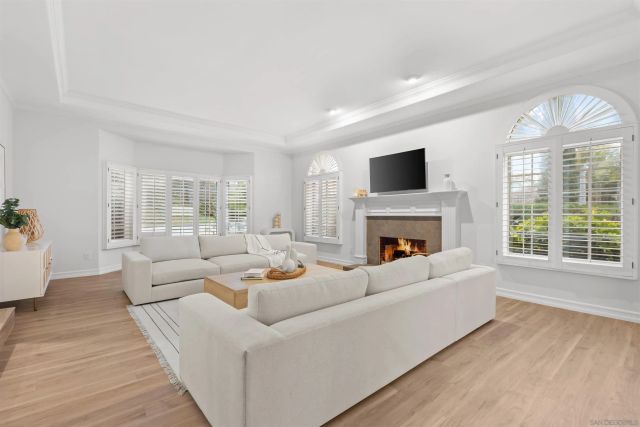 a living room with furniture large window and wooden floor