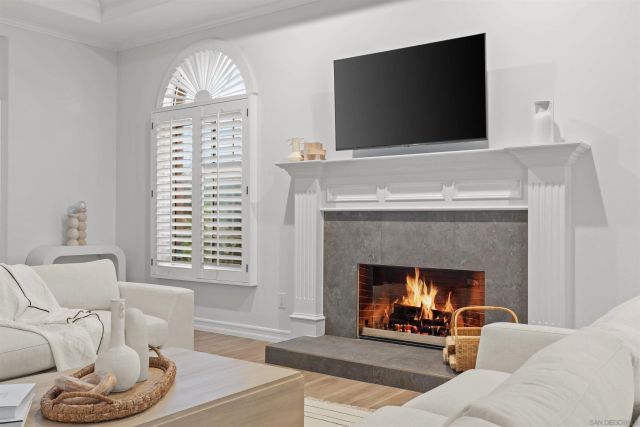 a living room with furniture a flat screen tv and a floor to ceiling window