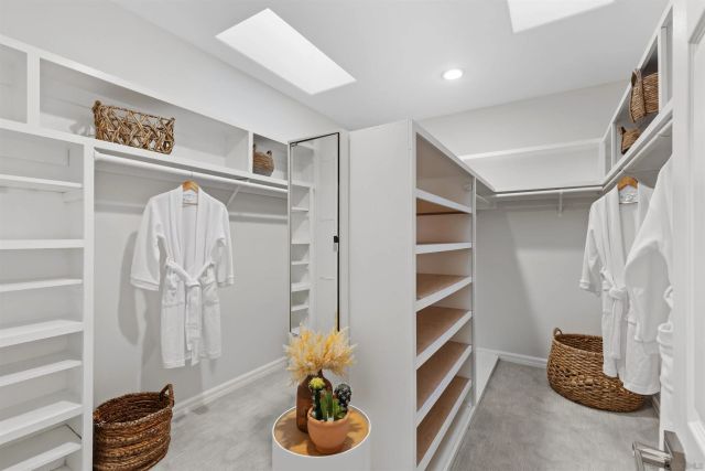 a kitchen with stainless steel appliances granite countertop a stove a sink a refrigerator and a white cabinets