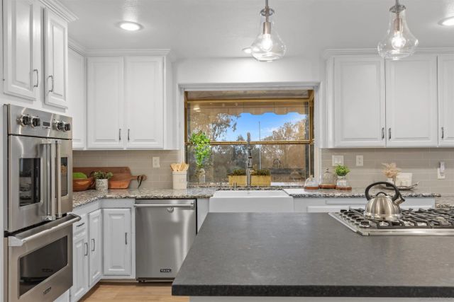 a kitchen with stainless steel appliances granite countertop a sink stove and refrigerator