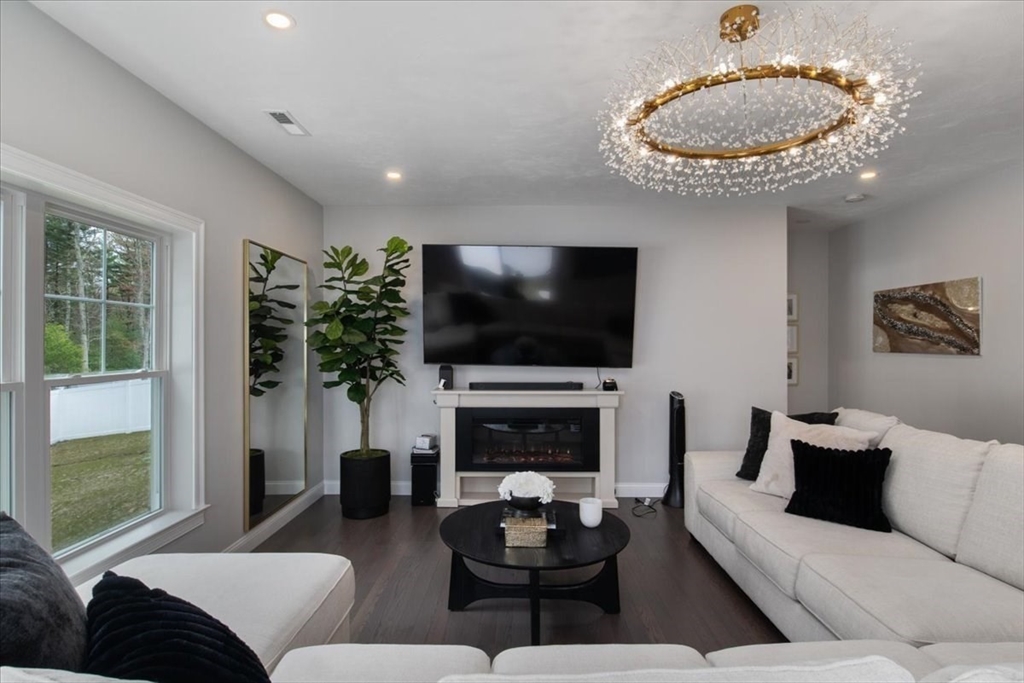 9 Iris Lane Bellingham, MA 02019 - Photo 14 of 34 a living room with furniture a flat screen tv and a fireplace