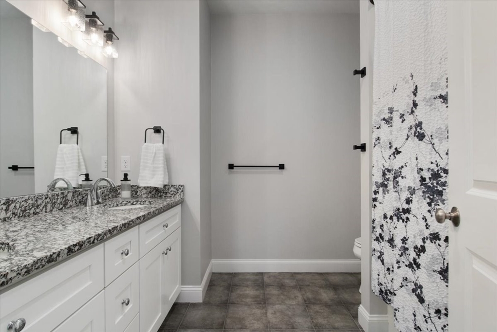 9 Iris Lane Bellingham, MA 02019 - Photo 22 of 34 a bathroom with a granite countertop sink a mirror and shower