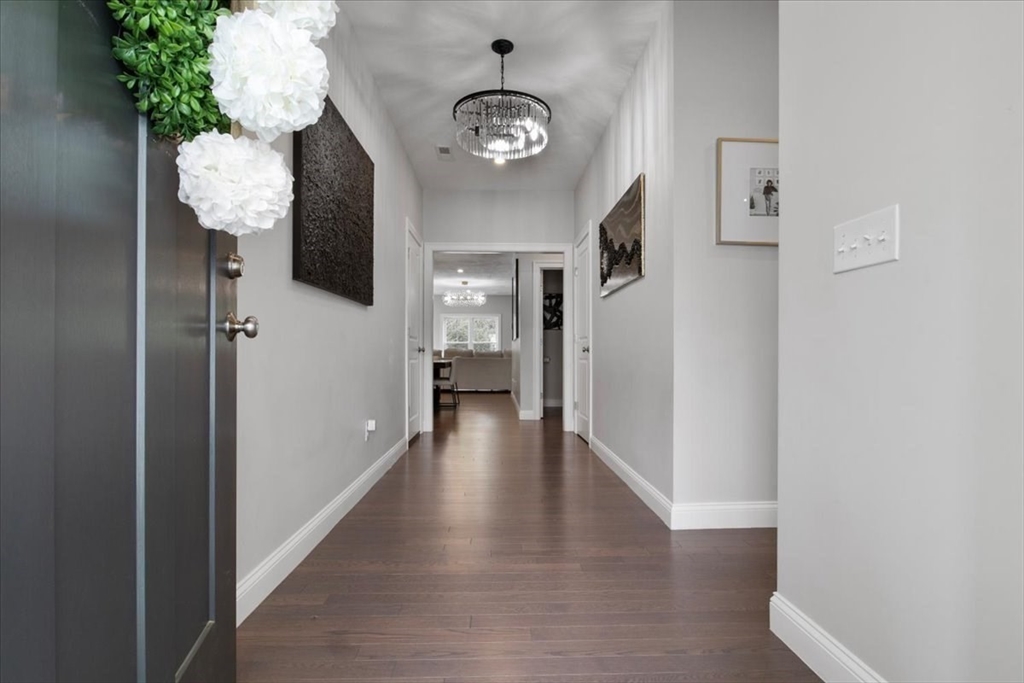 9 Iris Lane Bellingham, MA 02019 - Photo 5 of 34 a view of a hallway with wooden floor and a potted plant