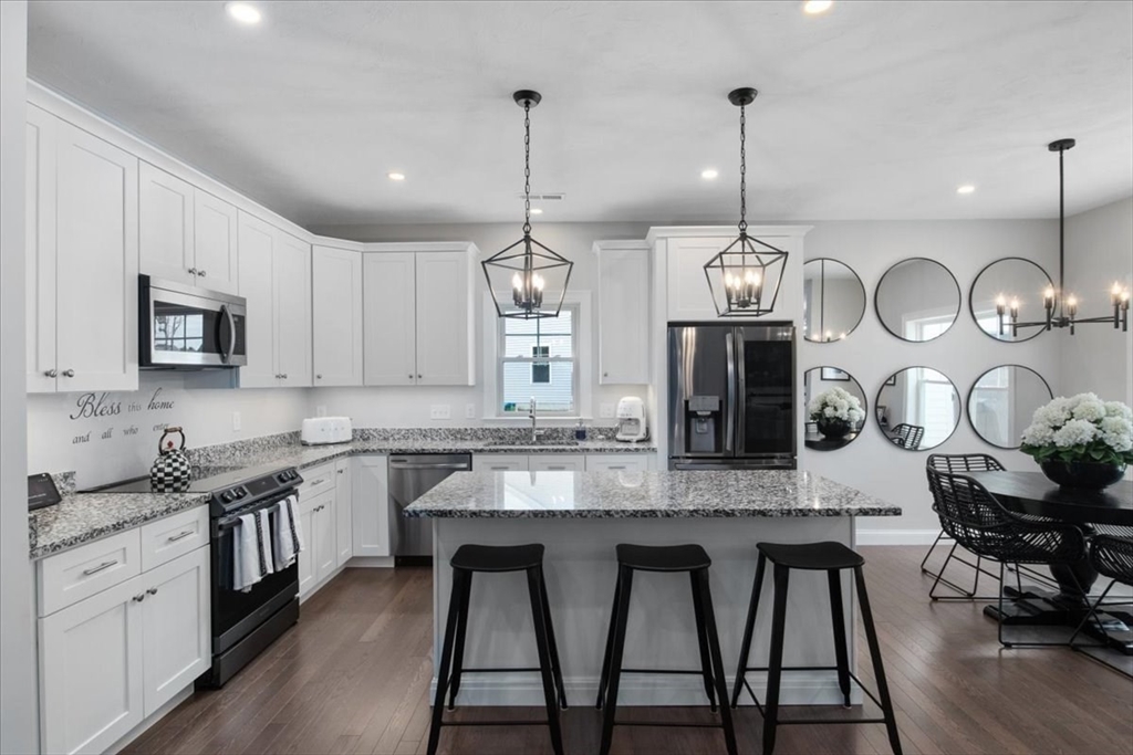 9 Iris Lane Bellingham, MA 02019 - Photo 7 of 34 a kitchen with stainless steel appliances granite countertop a sink a stove top oven a counter space and cabinets