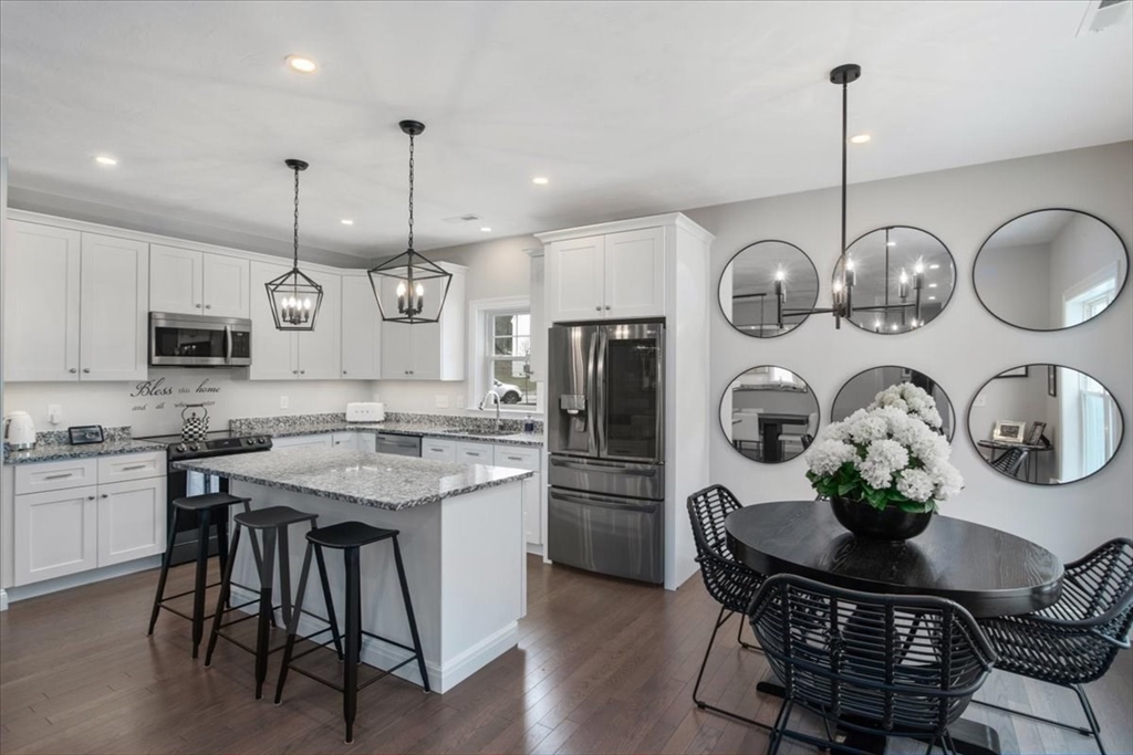 9 Iris Lane Bellingham, MA 02019 - Photo 9 of 34 a kitchen with stainless steel appliances granite countertop a sink a stove a oven a dining table and chairs
