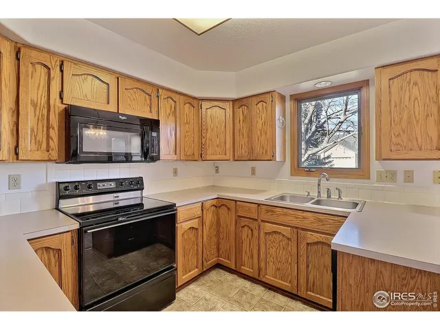 a view of a kitchen with a refrigerator and a sink