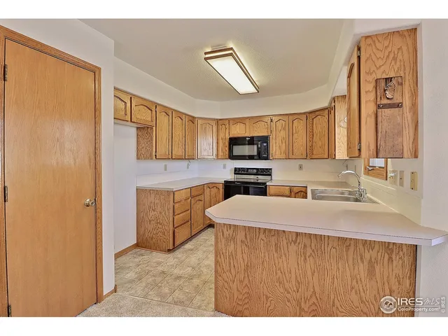 a kitchen with stainless steel appliances a refrigerator a sink a stove and white cabinets