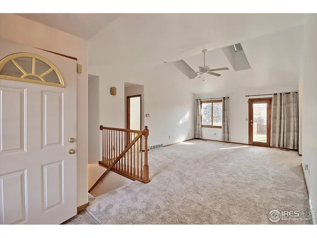 a view of a livingroom with entryway window and stairs