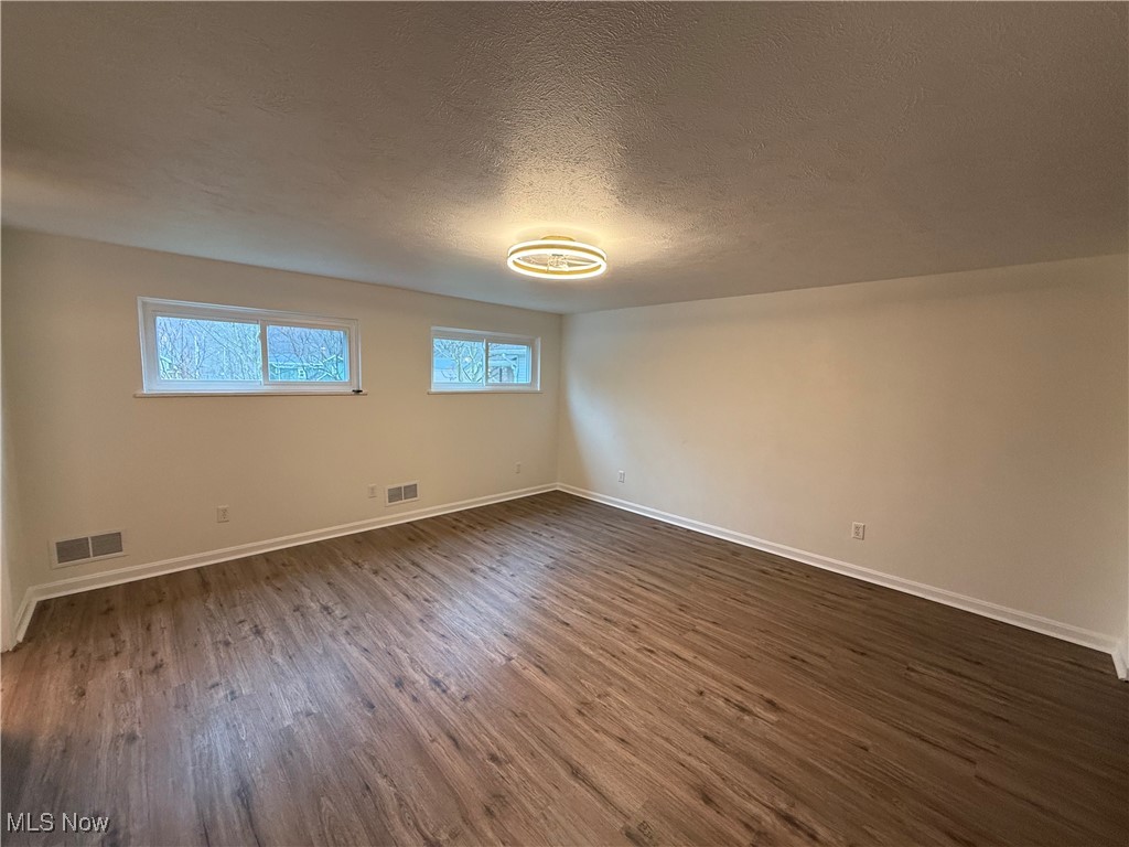 522 North 3rd Street Toronto, OH 43964 - Photo 21 of 47 Unfurnished room featuring dark wood-style floors and a textured ceiling