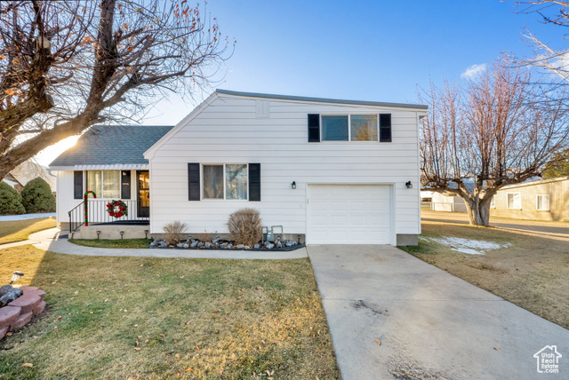 2418 South Daniels Road Daniel, UT 84032 - Photo 1 of 1 View of front of property with covered porch, a garage, and a front yard