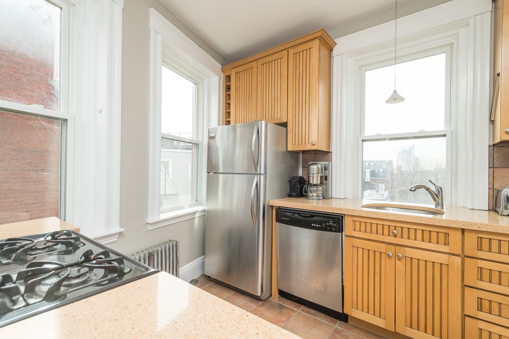 64 Chestnut Street, Unit 3 Boston, MA 02129 - Photo 4 of 9 a kitchen with stainless steel appliances granite countertop a stove a refrigerator and a window