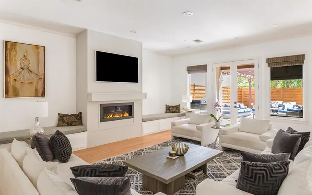 a living room with furniture a flat screen tv and a fireplace