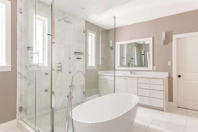 a bathroom with a tub shower sink and mirror