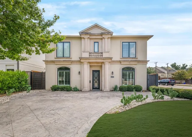 a front view of a house with a garden and plants