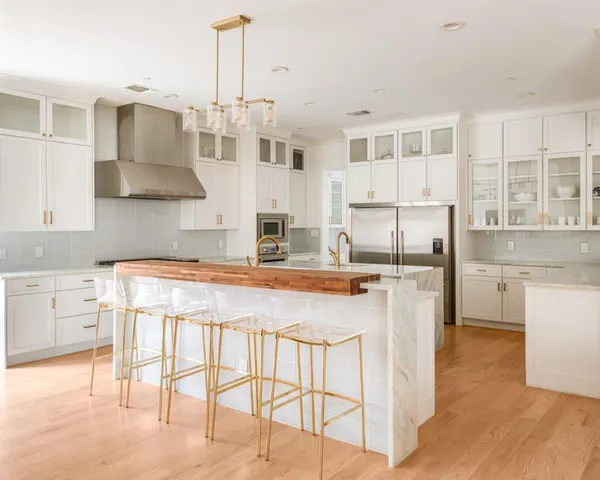 a kitchen with stainless steel appliances granite countertop a stove and white cabinets with wooden floor