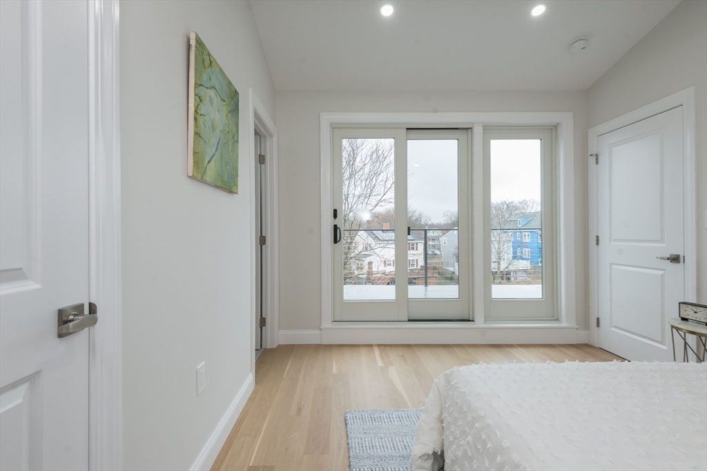 6 Gordon Road, Unit 6 Arlington, MA 02474 - Photo 31 of 40 a spacious bedroom with a large bed and a window with outer view